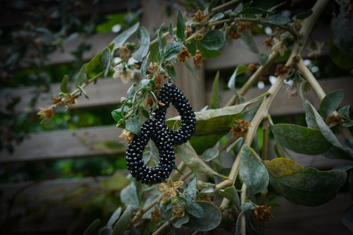 Black teardrop rhinestone dangle earrings editorial photograph